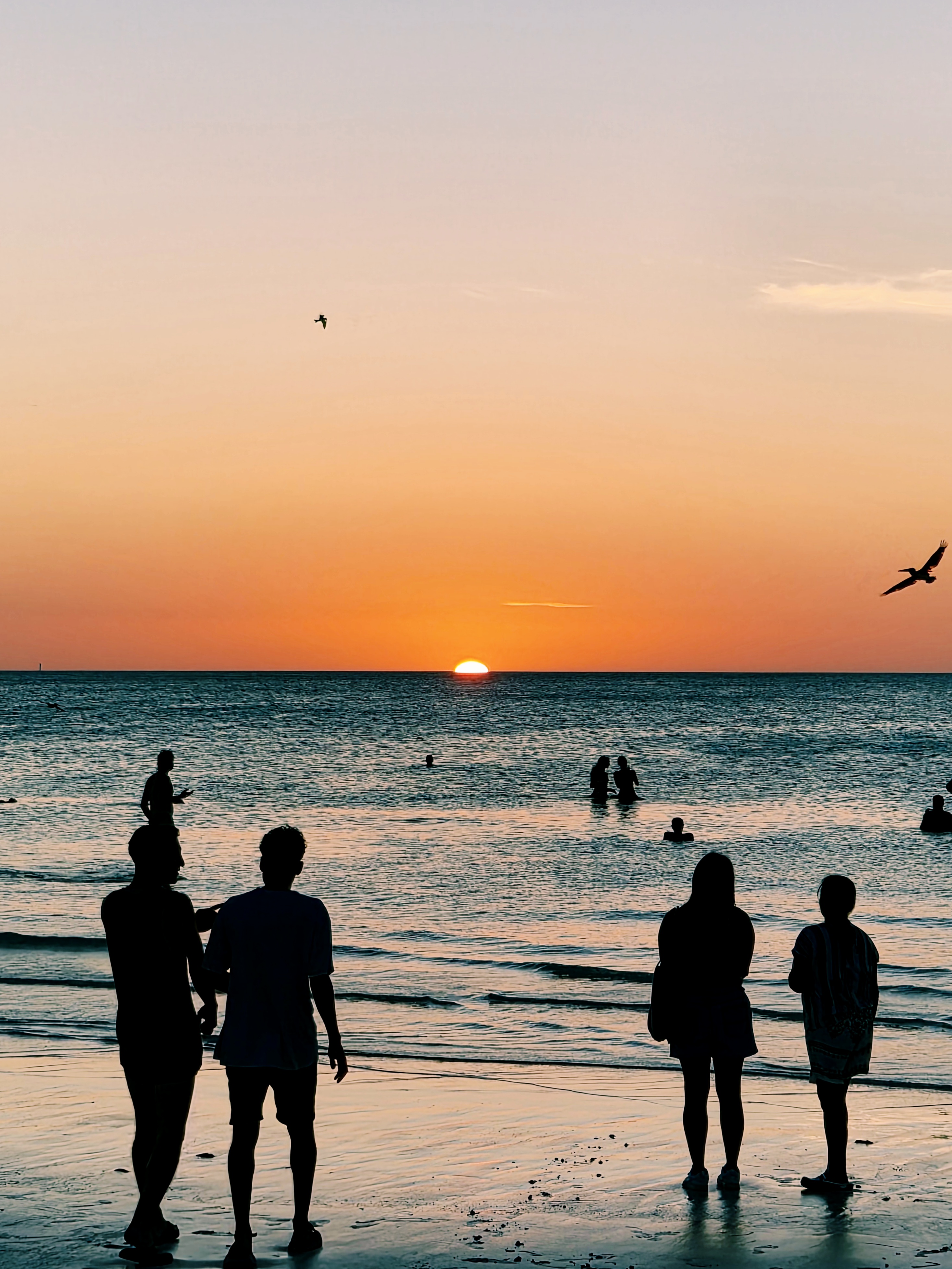 People at the waterline during sunset on Holbox.
